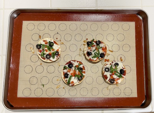 mini pizza bagels on cookie sheet