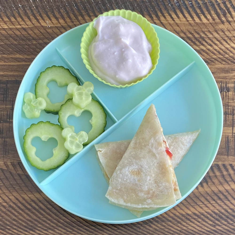 Toddler meal idea showing cucumbers, yogurt, and peanut butter strawberry banana quesadilla