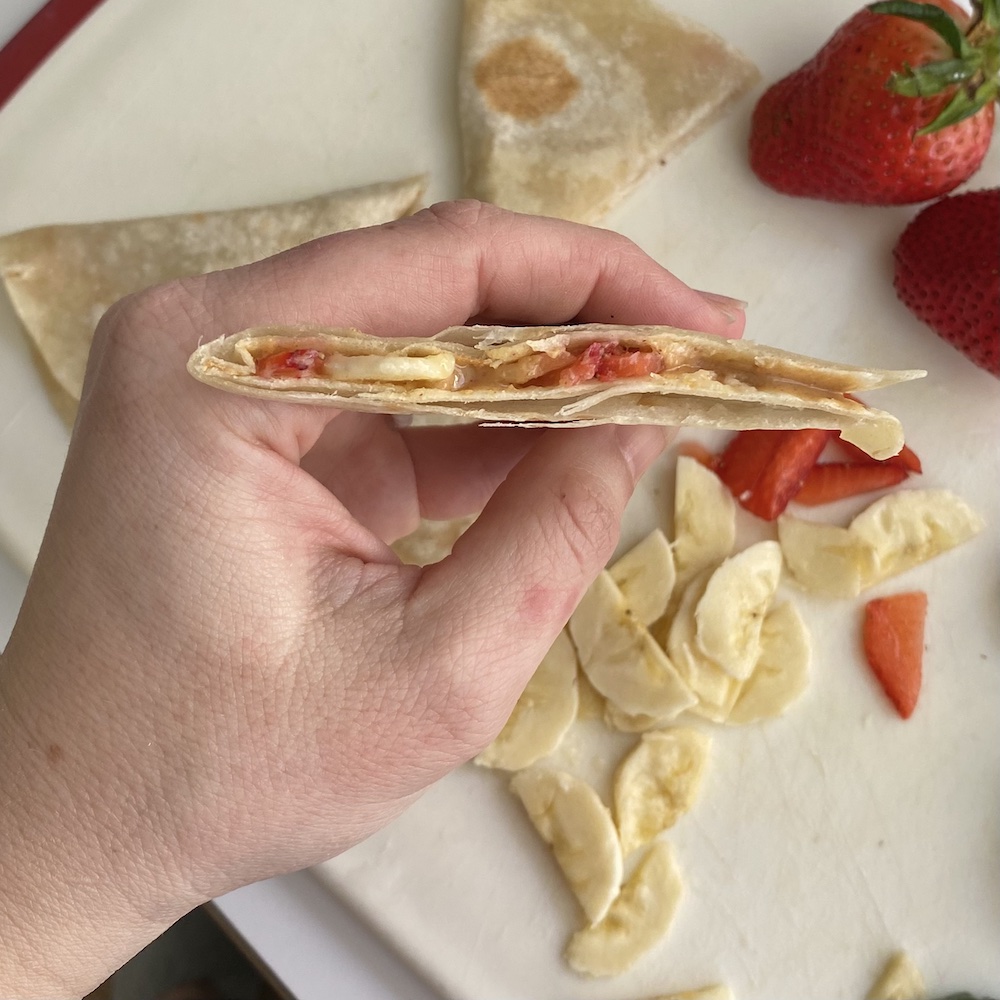 Holding peanut butter strawberry banana quesadilla